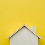 close-up-wooden-miniature-house-model-yellow-background_23-2148038666